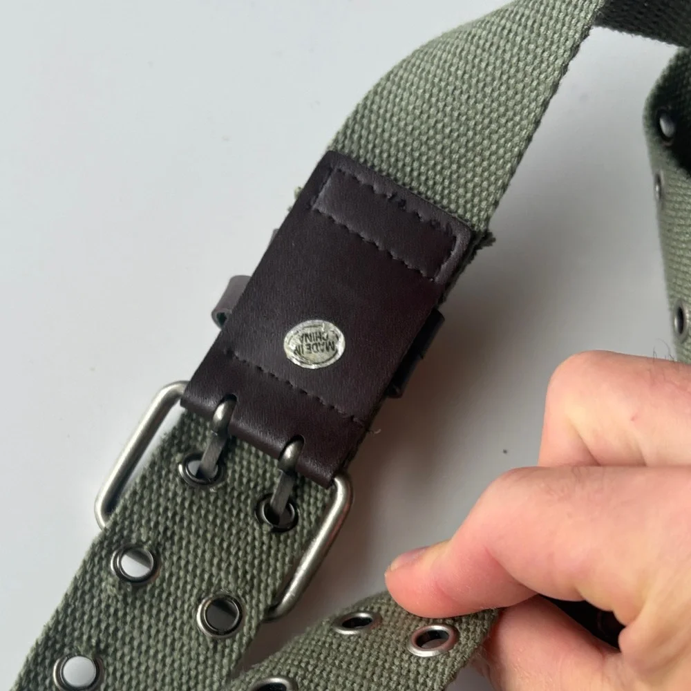 Olive Green Canvas Belt with brown accents. Silver tone hook loops.